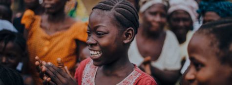 An African woman clapping and smiling